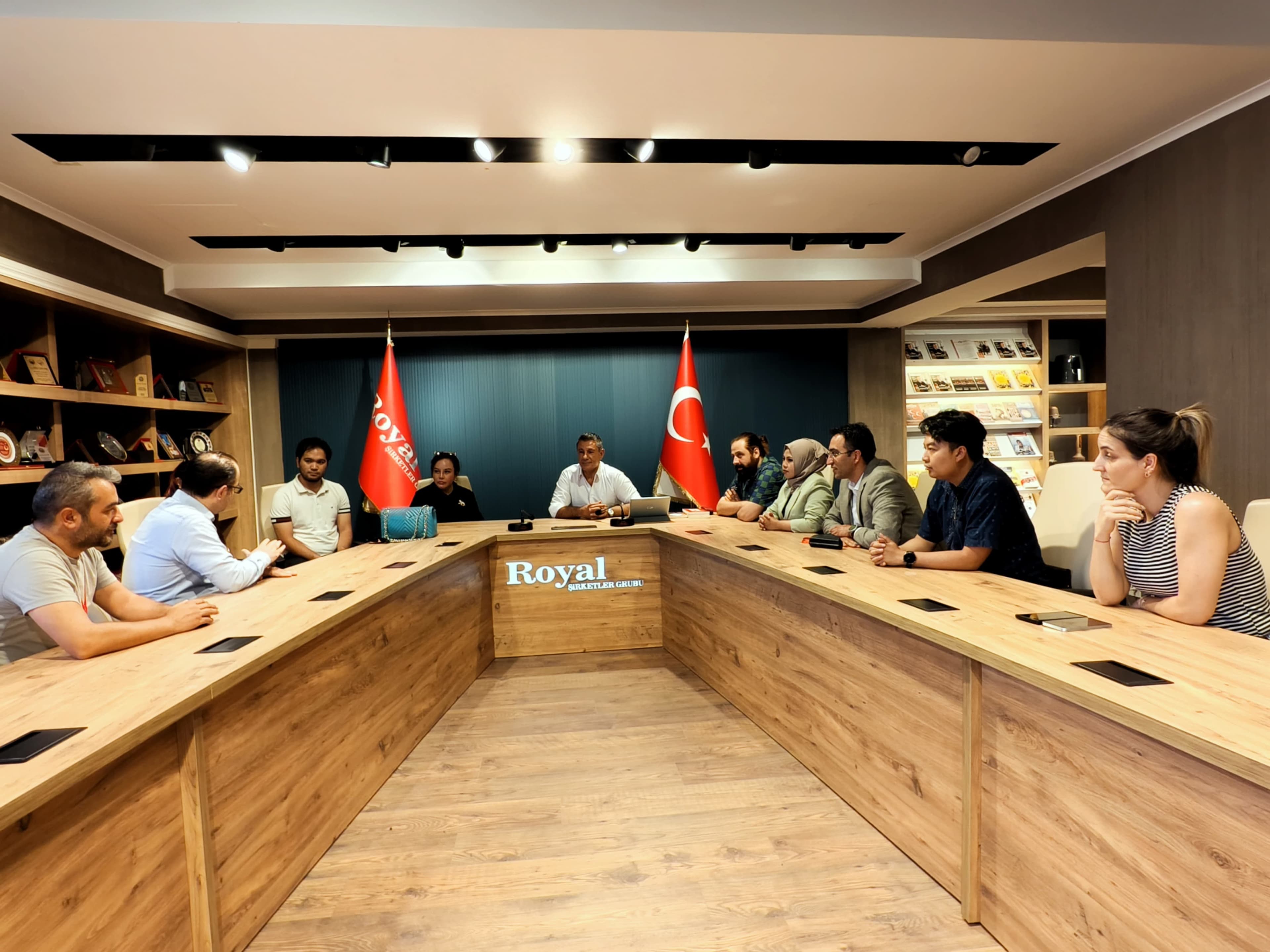 Kurumsal toplantı masasında tarafların ticari süreçleri değerlendirdiği geniş katılımlı görüşme